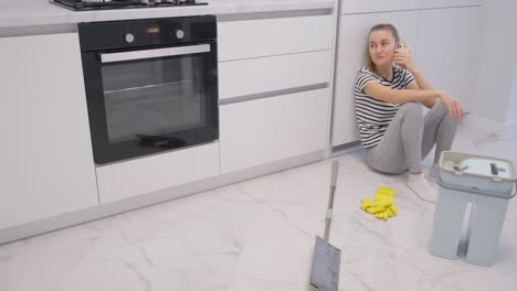 lazy african young talkative woman dialing mobile phone while her tired male colleague janitor