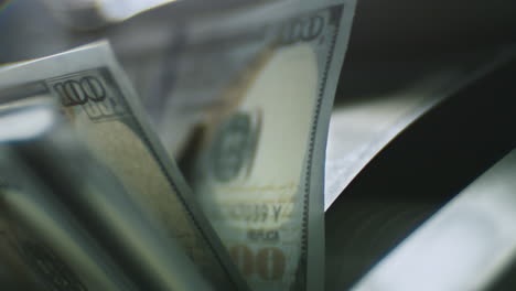 counting hundred dollar bills in a machine