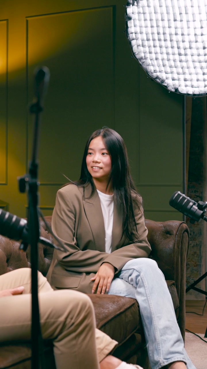 Giovane donna che partecipa a un'intervista podcast in uno studio.