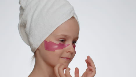 Smiling-child-girl-applying-pink-patches-under-eyes,-teenager-natural-skin-care,-perfect-fresh-clean