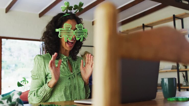 Donna multietnica con occhiali verdi e in costume che fa una videochiamata sul laptop a casa