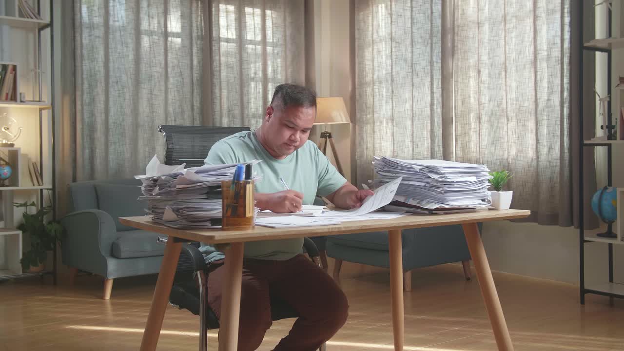 hombre gordo asiático trabajando duro con documentos en la oficina