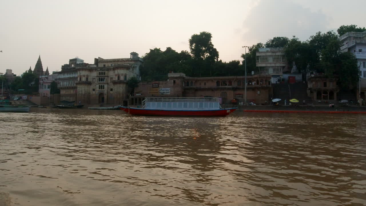 cinematográfica antigua ciudad santa varanasi india río ganges canal crucero en barco estado del norte en la provincia de ghat pradesh paisaje gris nublado fuego humo derecho seguir el movimiento