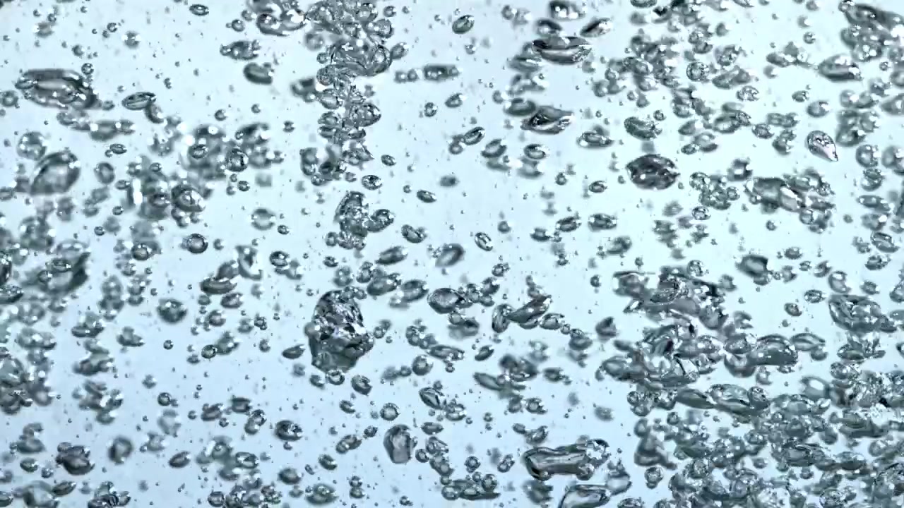 Primo piano di bolle d'aria scintillanti che salgono in acqua limpida