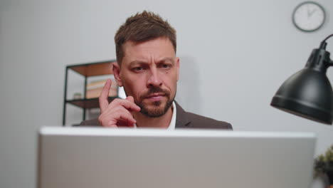 Close-up-businessman-freelancer-at-office-workplace-working-on-laptop-computer-sends-online-messages