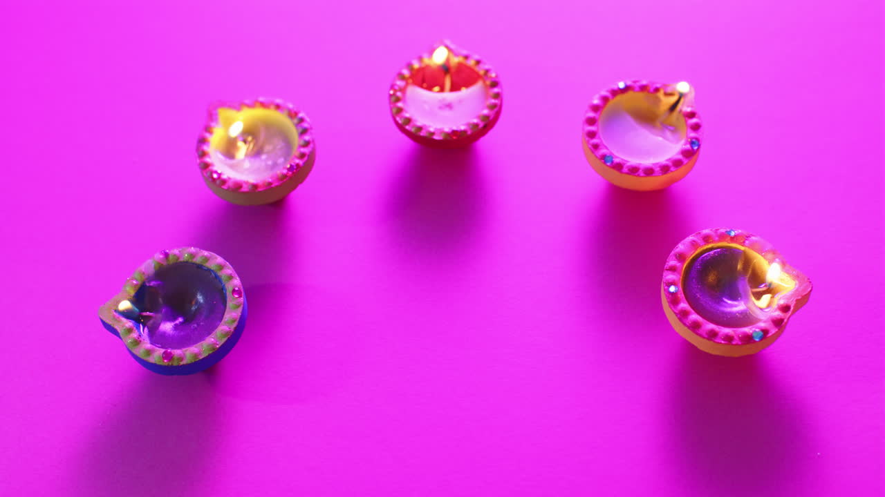 primer plano de las velas coloridas que queman celebrando diwali sobre un fondo púrpura
