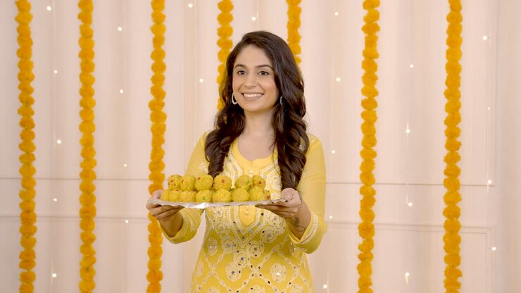 mujer india deseando feliz diwali con dulces