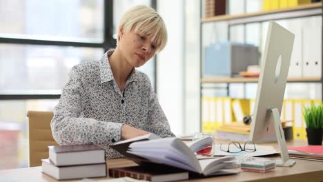 woman reading and working at an office desk