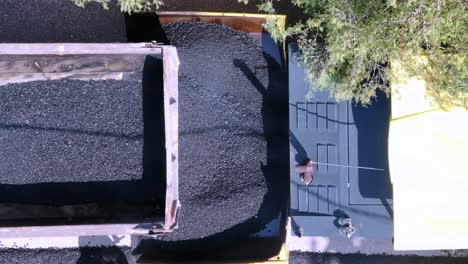 aerial shot 4k footage while truck pouring asphalt on asphalt machine