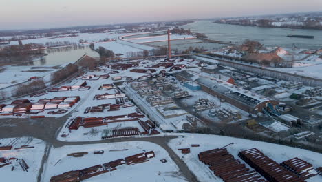 Flying-over-large-industrial-terrain-covered-in-snow