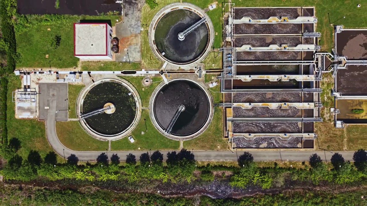 Industrial water treatment facility shown. Drone captures sewage plant with settling units. View from above displaying sewage processing units and environmental management zones