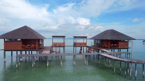 man carrying baggage or luggage and checking into a luxury private overwater villa on a tropical holiday