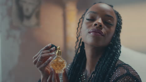 una foto de una chica caucásica aplicando perfume en su dormitorio.