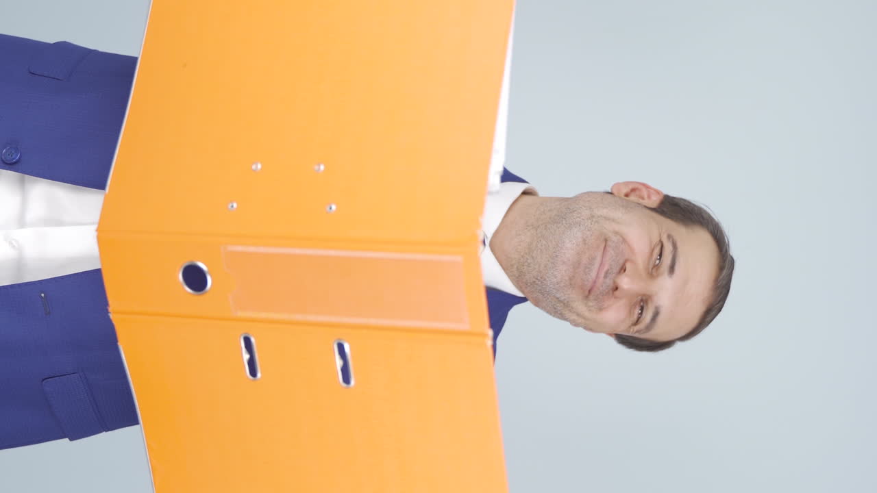 Vertical video of Businessman looking from behind files.