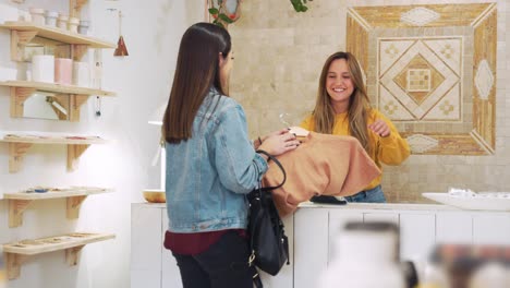cliente pagando por ropa en el mostrador de ventas con tarjeta de crédito en una tienda de moda