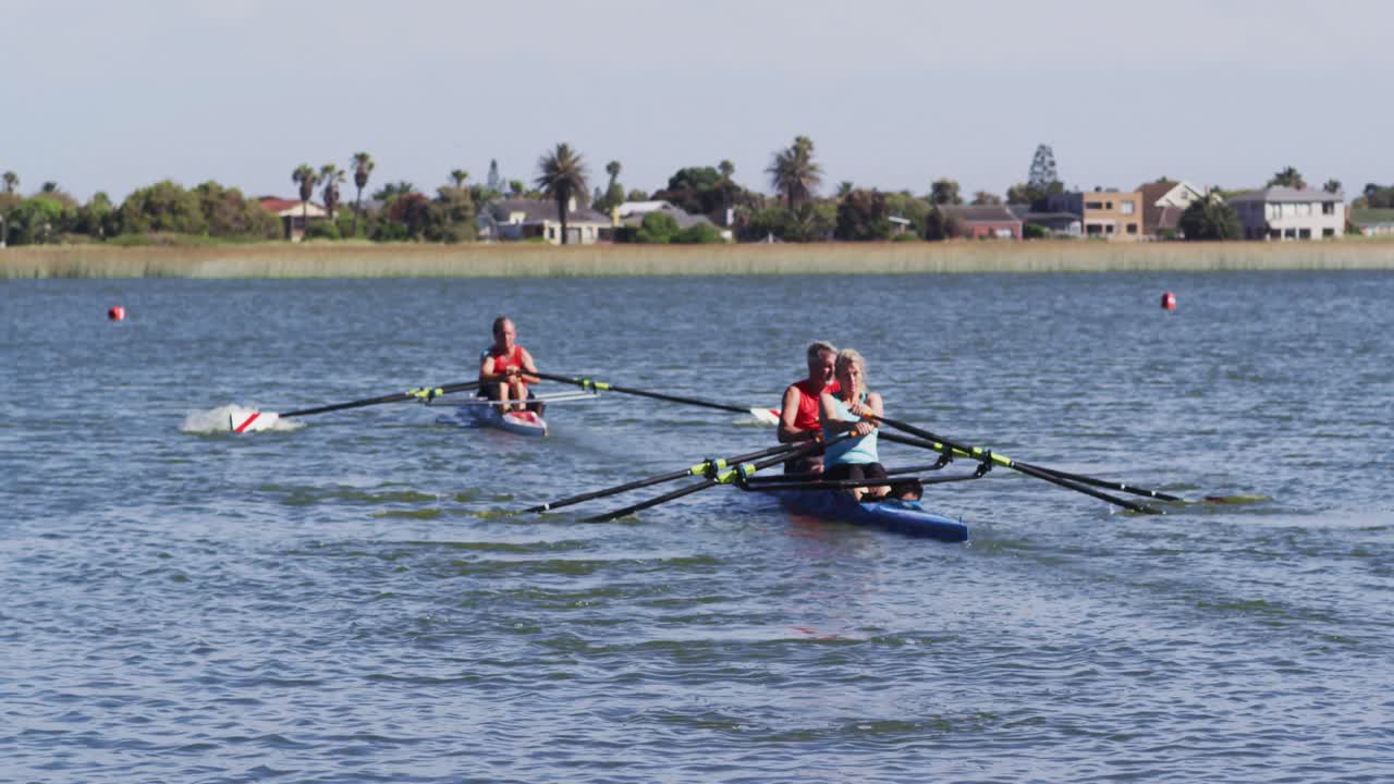 Four senior caucasian men and women rowing boat on a river