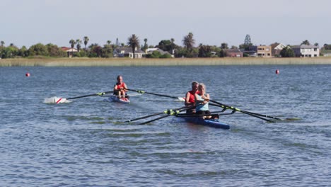 four senior caucasian men and women rowing boat on a river