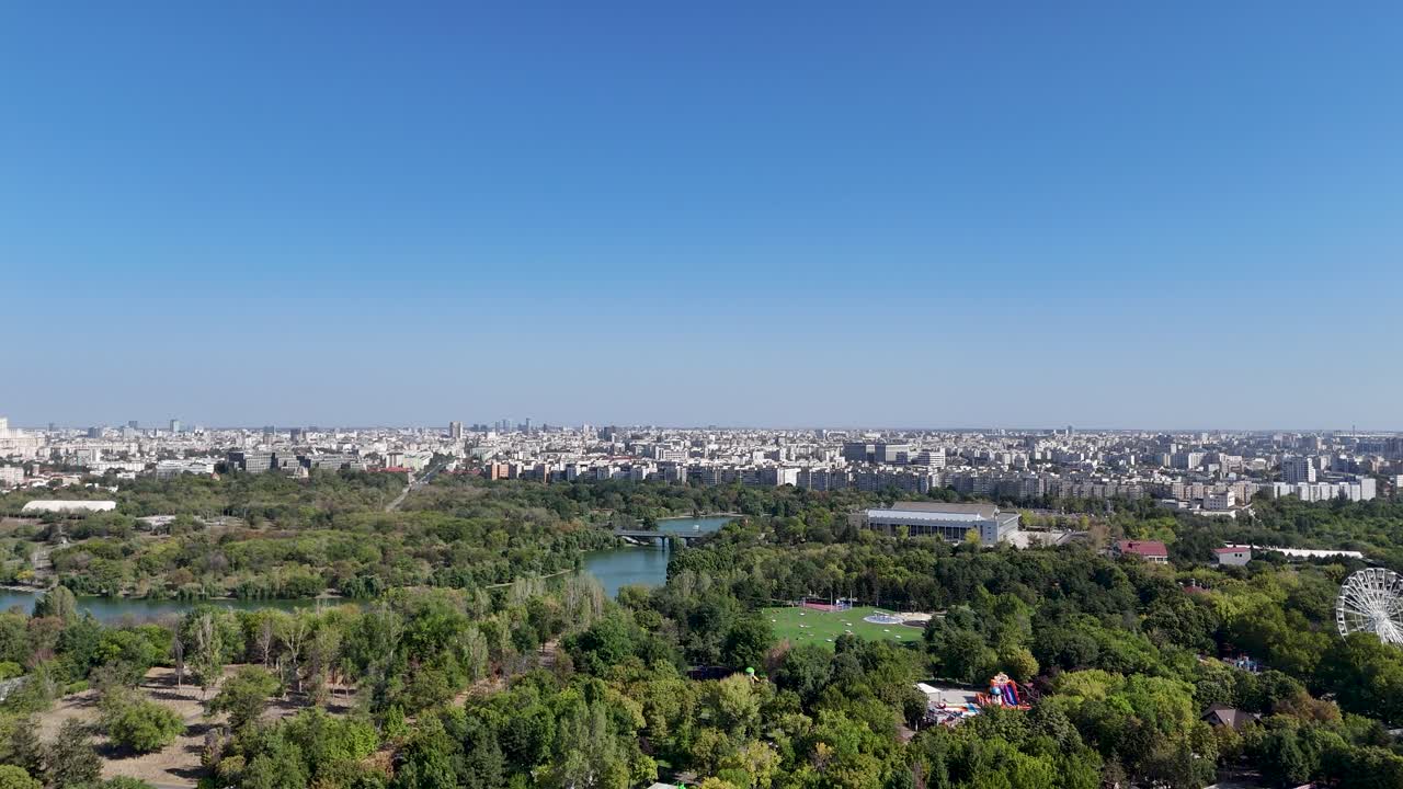 Rotating Drone View Over Tineretului Park, Surrounded By Greenery and Lakes with Bucharest's Skyline in the Background, Romania