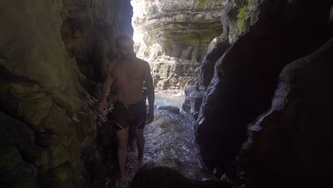 young man entering the sea cave.