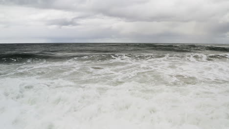 Vista-Frente-Al-Mar-De-Las-Olas-Del-Océano-Rompiendo-En-La-Costa-Con-El-Cielo-Nublado,-Costa-De-Neskowin-Oregon,-Estados-Unidos