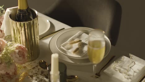 table set for meal at wedding reception with champagne in ice bucket