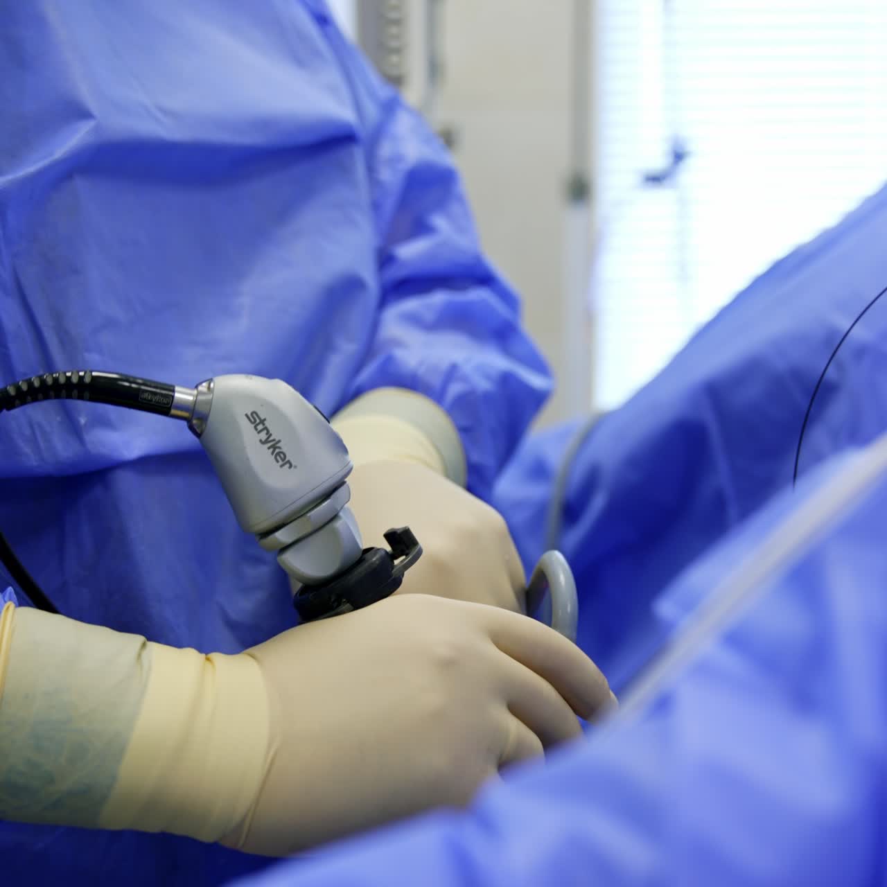Surgeon shoves the wire into the modern tool. Professional carefully moves the instrument down. Close up. Vertical screen
