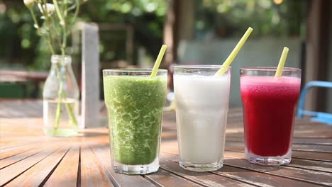 rack focus on three colorful healthy juice smoothies