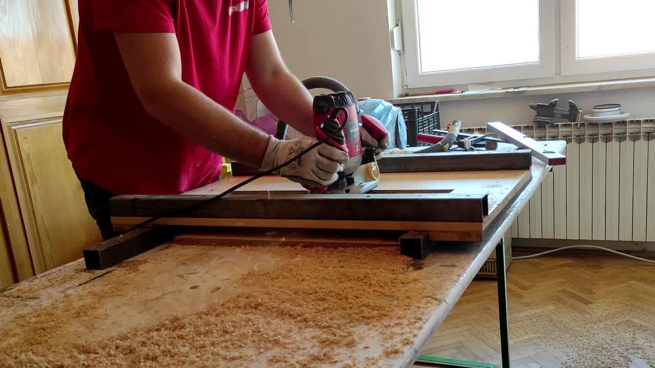 Woodworker working withe milling router machine in small home workshop