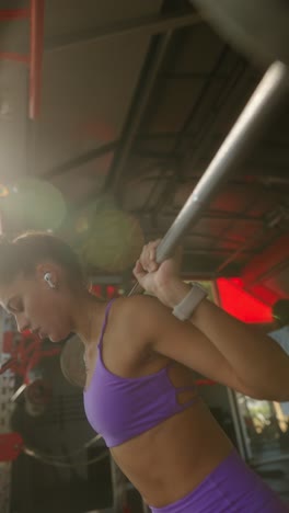 young woman performing barbell squats in a gym