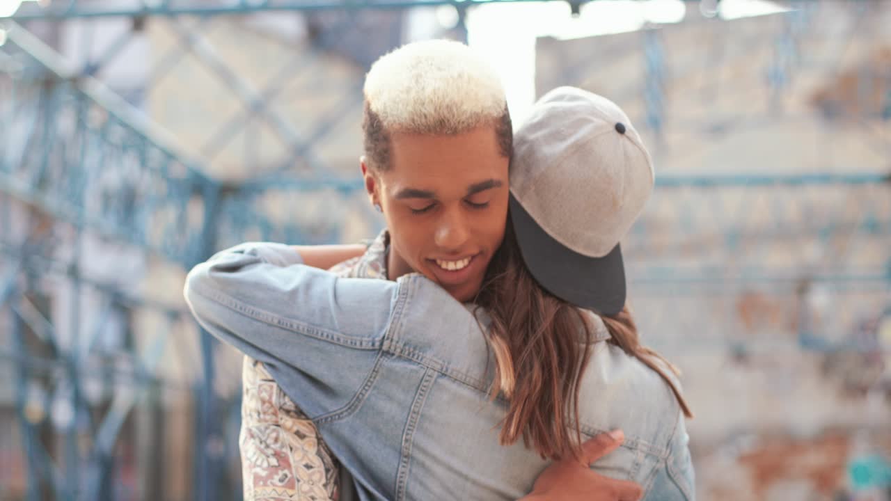 Close-up view of hipster happy couple hugging in the street