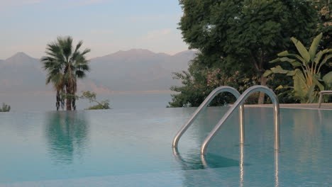 Escena-De-Resort-Con-Piscina-Con-Vistas-Al-Mar-Y-A-Las-Montañas.