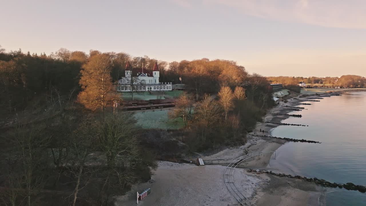 Drone footage of Marselisborg Forest, the beach and Varna Mansion in late autumn near Aarhus, Denmark. Bare trees and soft coastal light capture a quiet Nordic atmosphere