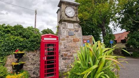 iconic red phone booth beside historic clock tower