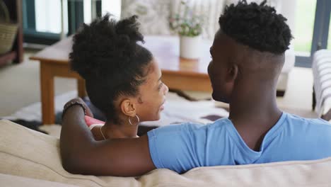 Video-Eines-Glücklichen-Afroamerikanischen-Paares,-Das-Auf-Dem-Sofa-Sitzt-Und-Sich-Umarmt