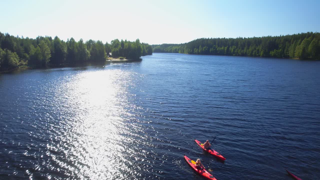Ryhmä ihmisiä melomassa joella auringonpaisteessa