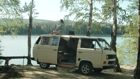 woman taking pictures from roof of camper van