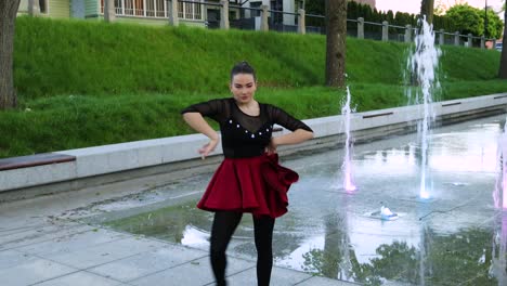hermosa bailarina blanca bailando junto a una fuente