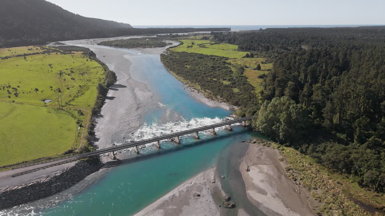 Ponte a una corsia che attraversa un fiume azzurro di acqua di disgelo che sfocia nell'oceano