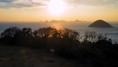 Flight-over-pavilion-on-top-of-Clearwater-Bay-towards-sunset,-Hong-Kong