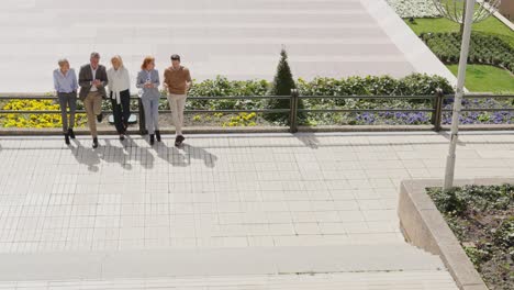 a group of business people walking and talking outdoors in an urban setting