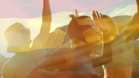 Animation-of-waving-flag-of-ghana-over-group-of-friends-having-fun-on-the-beach