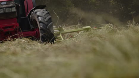 low pov handheld shot of tractor mowing grass