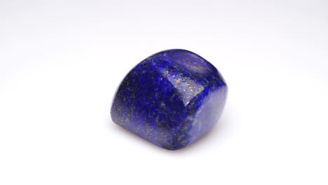 piedra preciosa natural de lapis lazuli en el fondo blanco en la mesa de giro