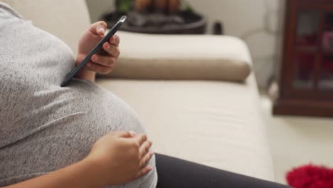 a young pregnant woman using a phone