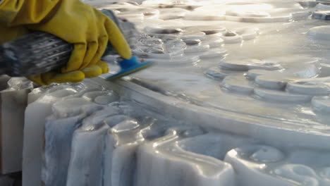 Sculptor-in-workwear-grinding-white-marble-stone-at-the-working-space,-Da-Nang-city,-Vietnam,-close-up