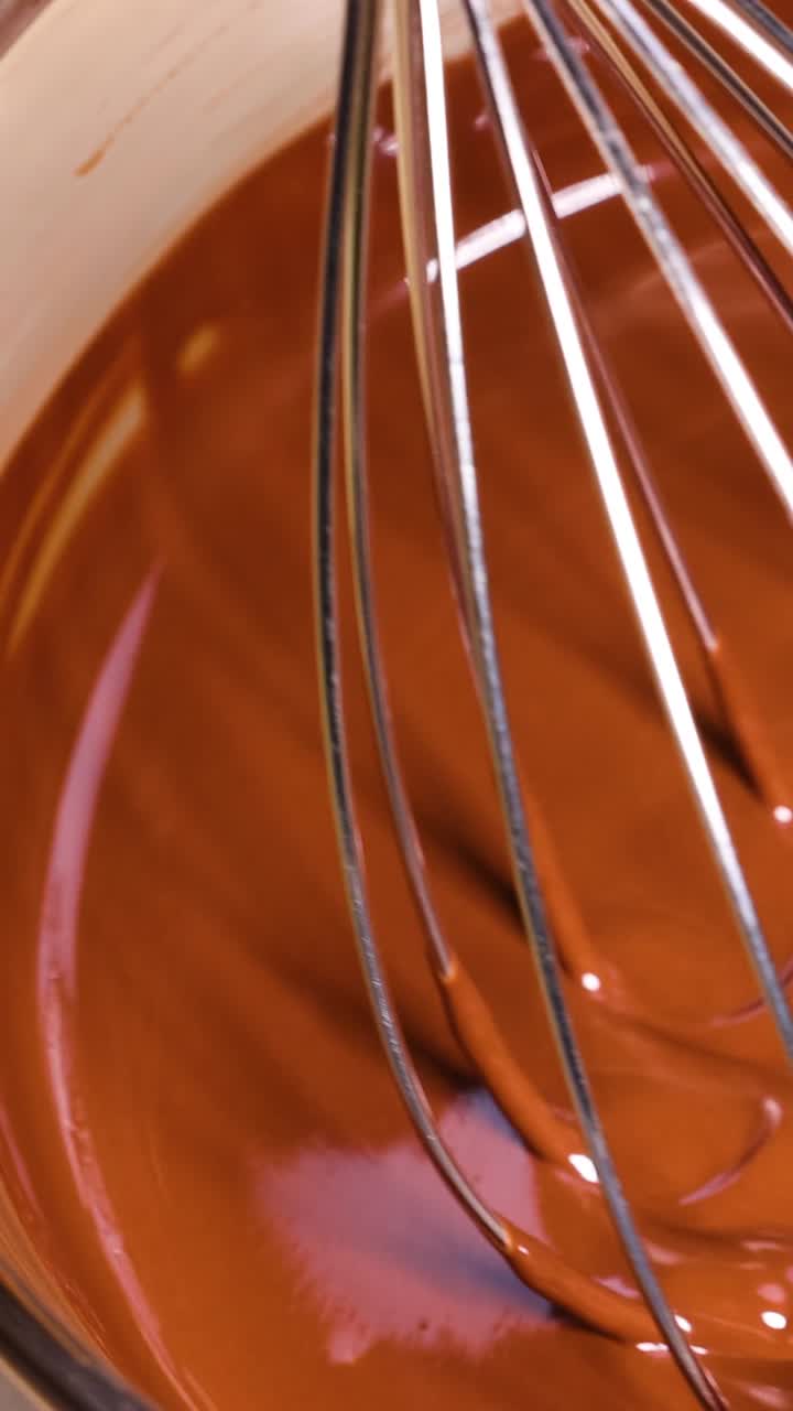 batir mezclando chocolate derretido en un tazón de vidrio