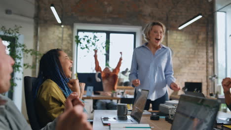 excited businesswoman rejoice success with happy multiethnic team in office.
