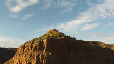 aerial view tilting over rocky cliffs and desert, sunny evening in utah, usa