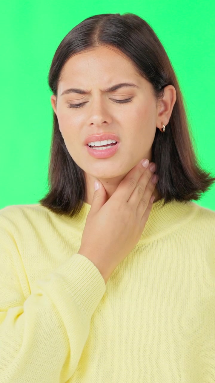 Young Woman Suffering From Sore Throat Against Green Screen