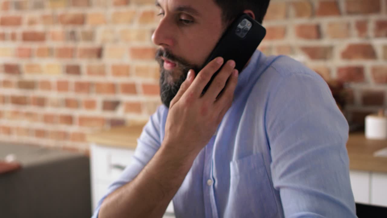 Tilt up video of man using mobile phone and laptop